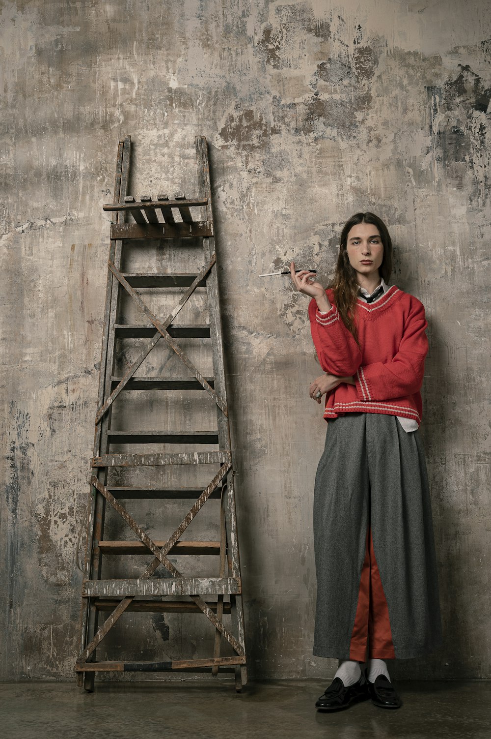 woman in red long sleeve dress standing beside brown wooden ladder