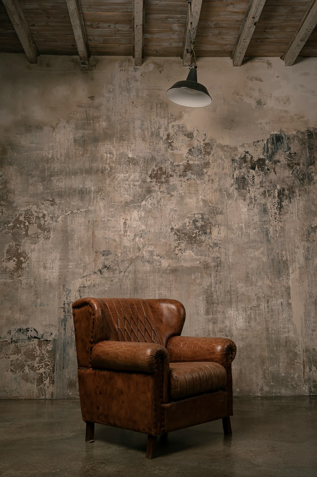 brown wooden armchair beside white wall