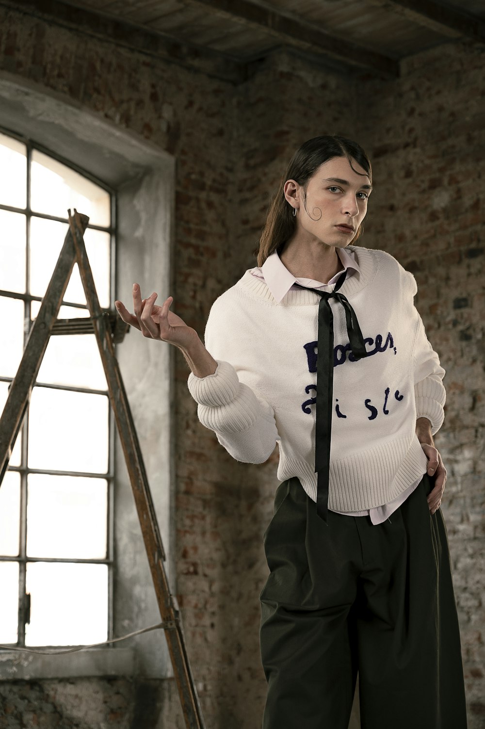 woman in white long sleeve shirt and black pants standing on ladder