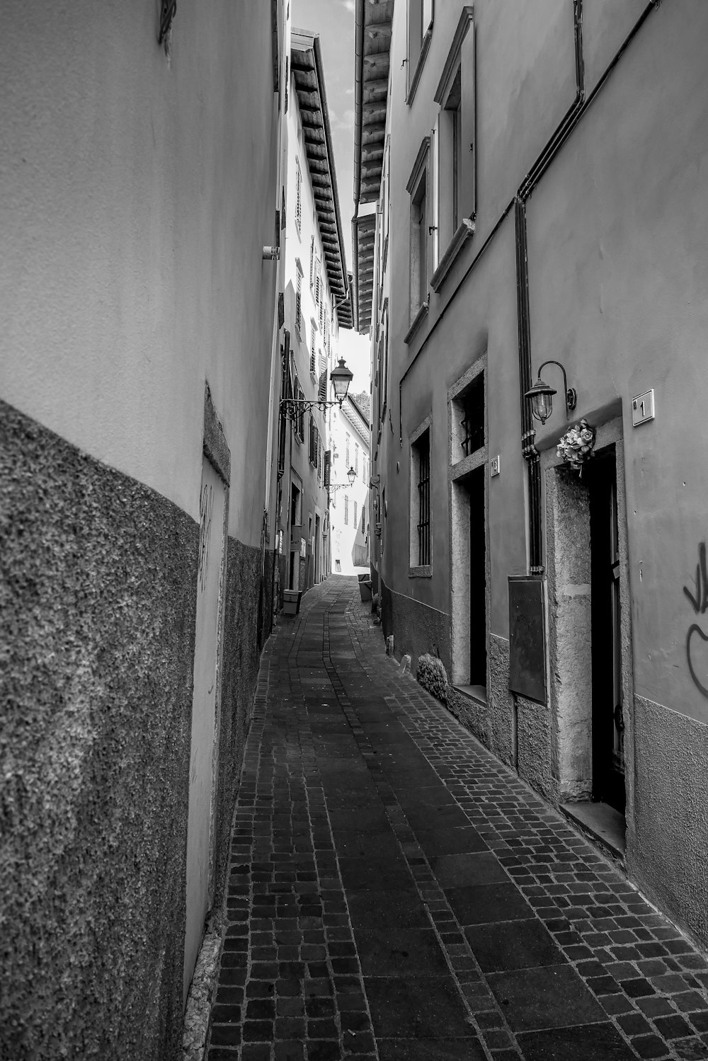 grayscale photo of alley between buildings