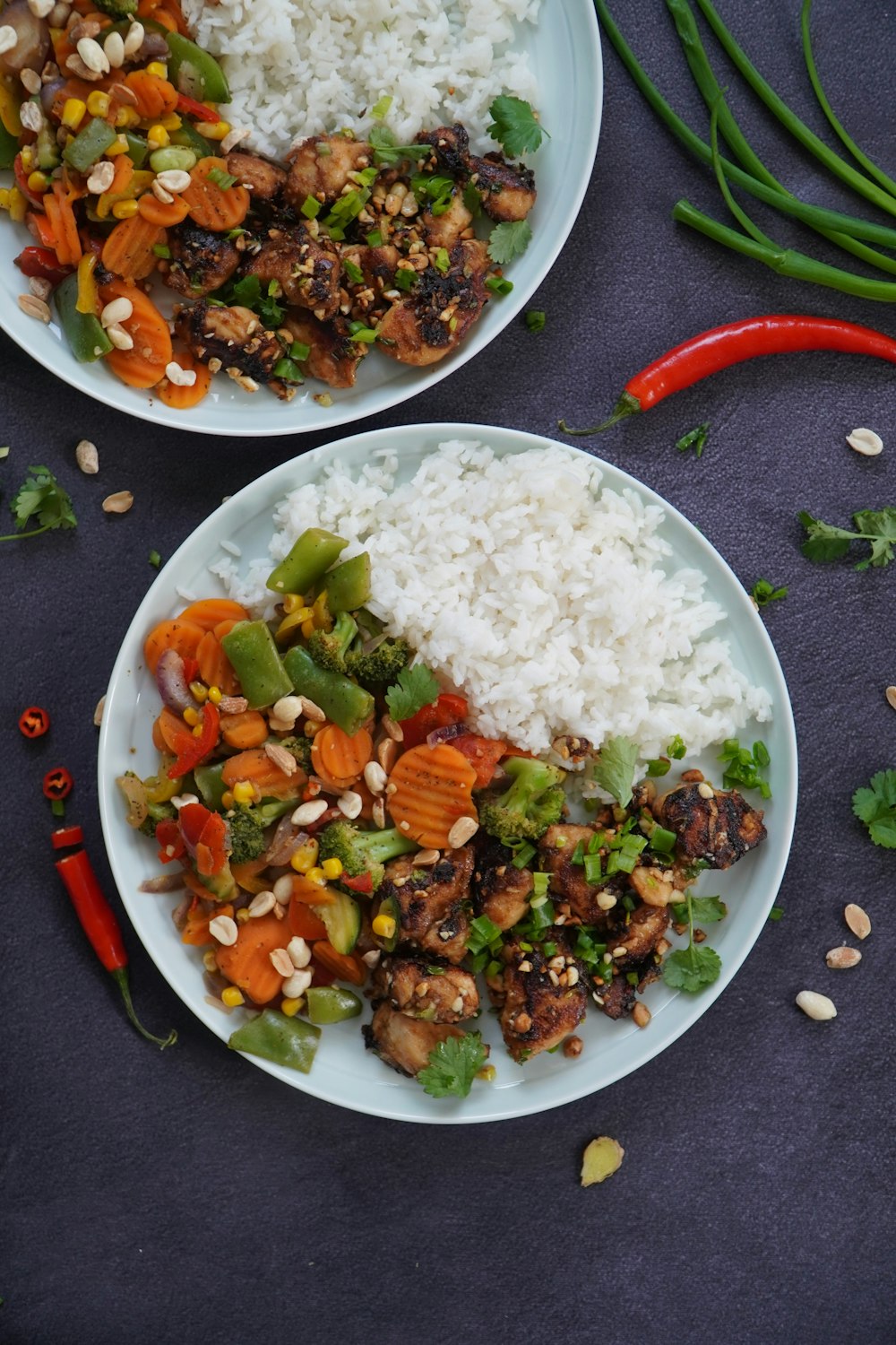 cooked rice with sliced carrots and green vegetable on white ceramic plate