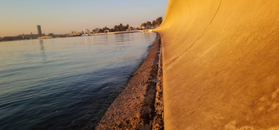 A panoramic view of a custom-colored seawall protecting a waterfront property on a sunny day.
