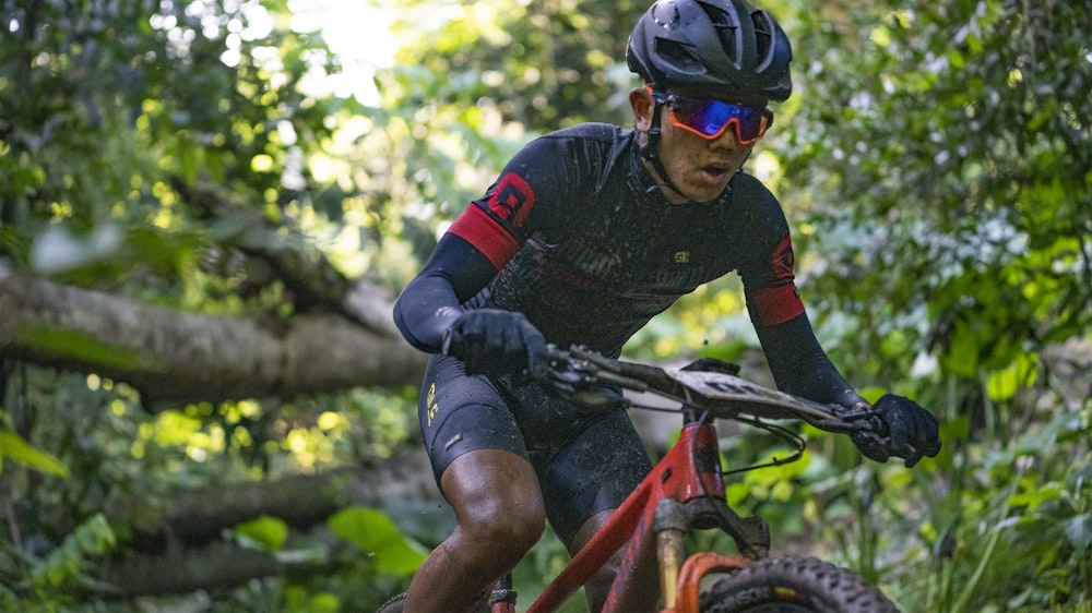 man in black and red long sleeve shirt riding on red and black mountain bike