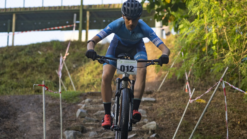 man in red and blue jacket riding black mountain bike