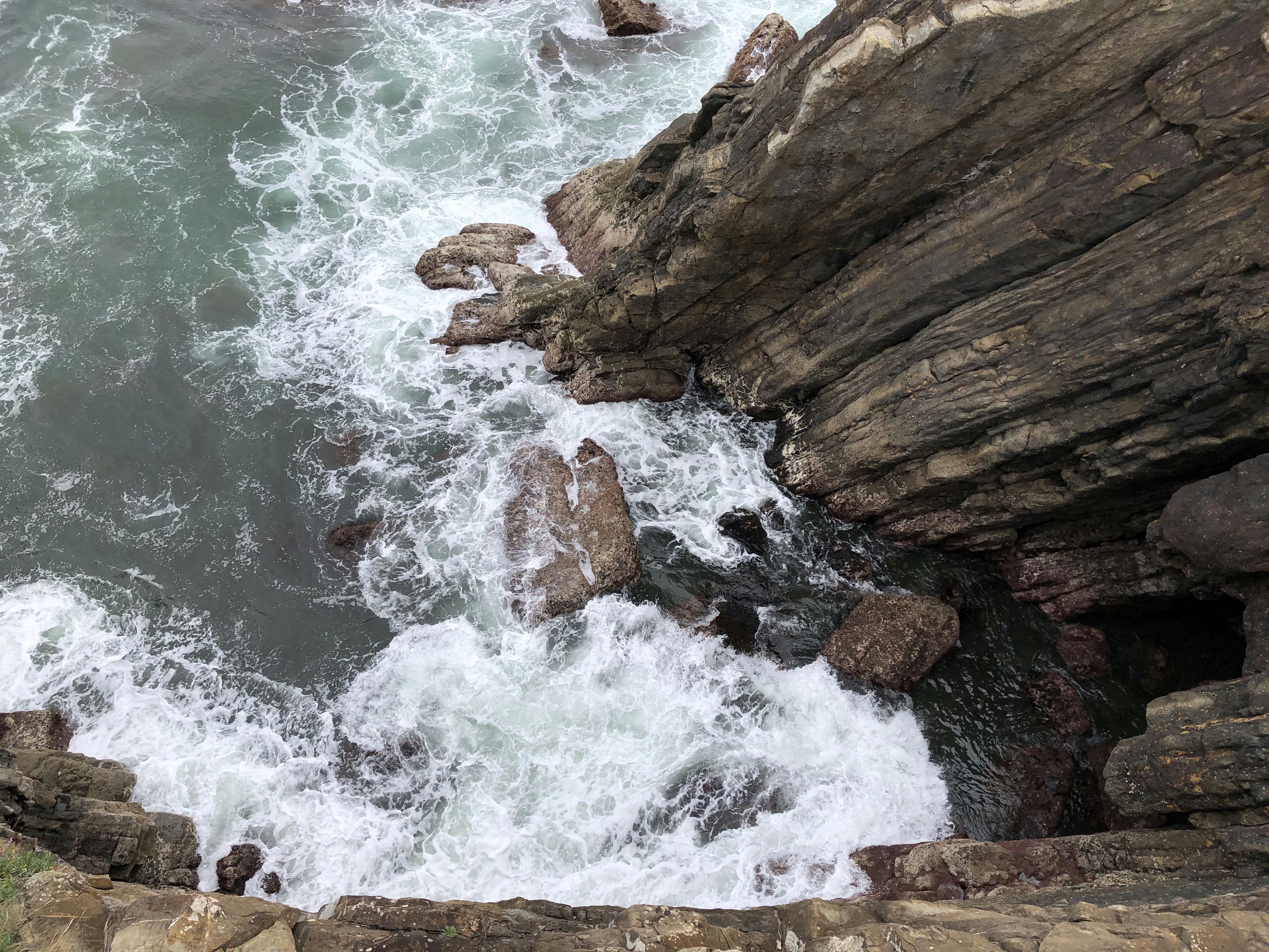 brown rock formation beside body of water during daytime