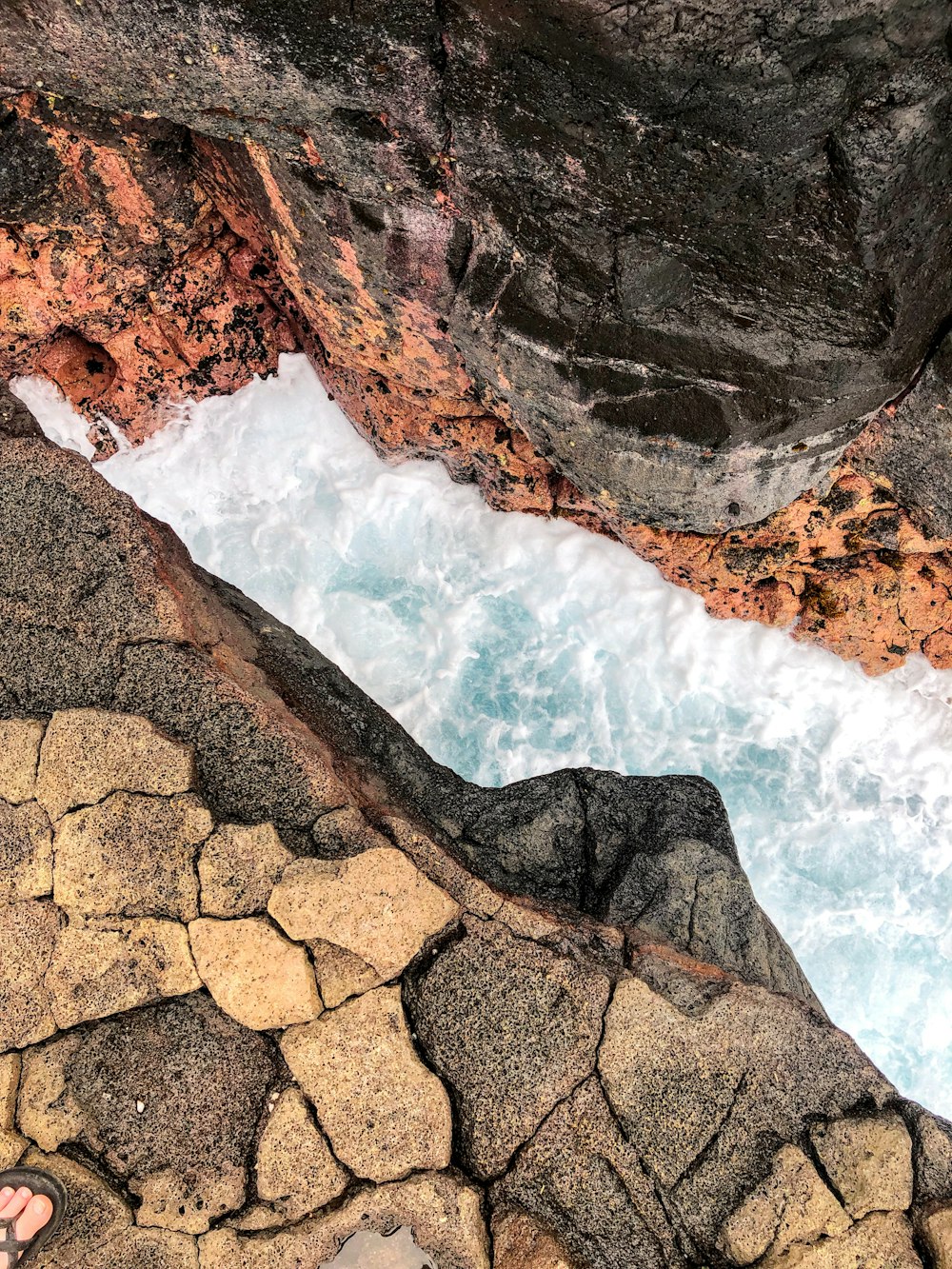 water falls on rocky shore during daytime