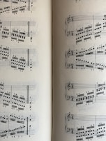 A page from a musical score with a series of staffs displaying treble and bass clefs, filled with an arrangement of musical notes and symbols. The notes vary in pitch and rhythm, indicating a complex composition. The sheet music is open to two pages, visible on both the left and right sides.