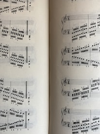 A page from a musical score with a series of staffs displaying treble and bass clefs, filled with an arrangement of musical notes and symbols. The notes vary in pitch and rhythm, indicating a complex composition. The sheet music is open to two pages, visible on both the left and right sides.