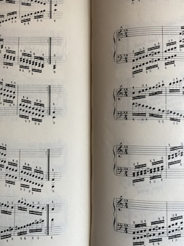 A page from a musical score with a series of staffs displaying treble and bass clefs, filled with an arrangement of musical notes and symbols. The notes vary in pitch and rhythm, indicating a complex composition. The sheet music is open to two pages, visible on both the left and right sides.