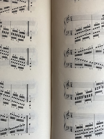 A page from a musical score with a series of staffs displaying treble and bass clefs, filled with an arrangement of musical notes and symbols. The notes vary in pitch and rhythm, indicating a complex composition. The sheet music is open to two pages, visible on both the left and right sides.