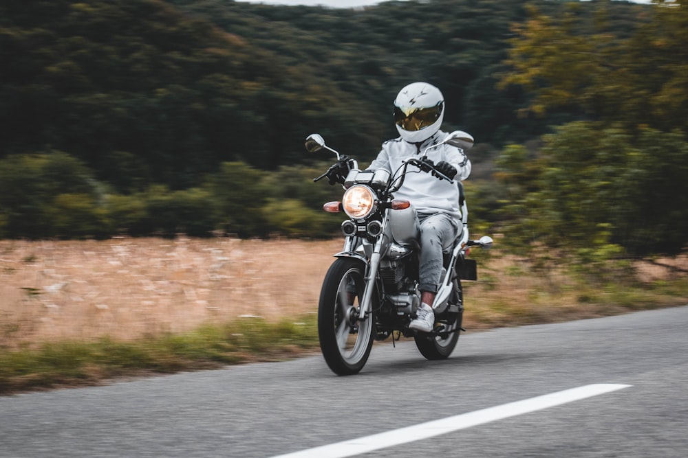 man in white helmet riding motorcycle on road during daytime