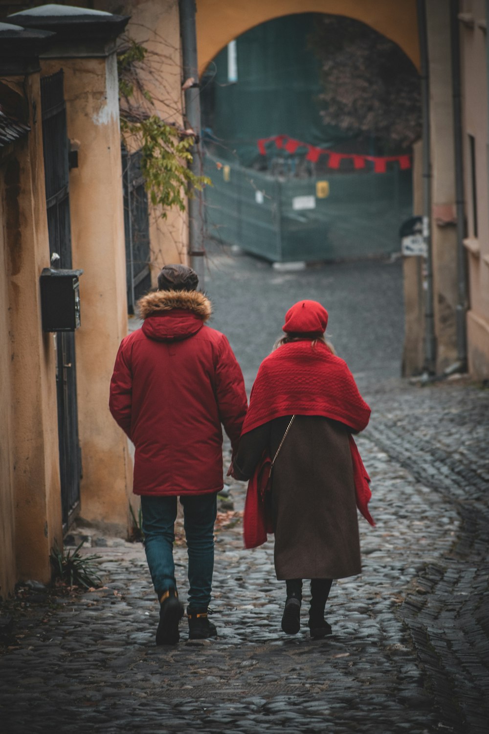 man in red hoodie walking on street during daytime