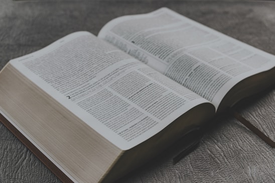 opened book on brown wooden table