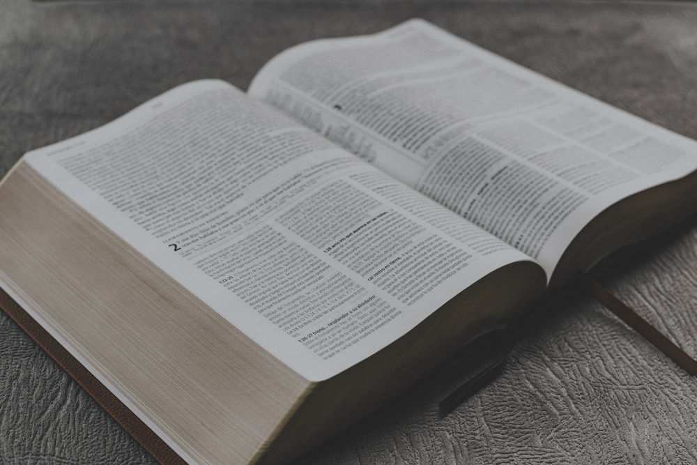 opened book on brown wooden table