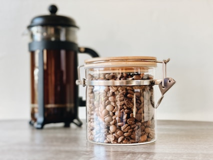 Bocal en verre transparent avec du café en grains à l'intérieur