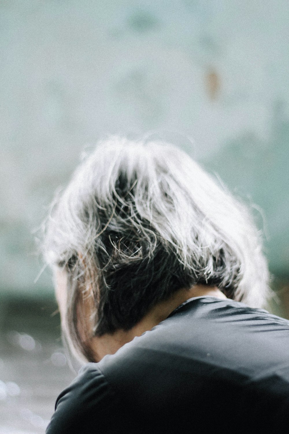 person in black shirt with white and black hair