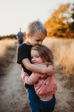 photography poses for family,how to photograph boy in black t-shirt hugging girl in red and white polka dot dress
