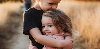 boy in black t-shirt hugging girl in red and white polka dot dress