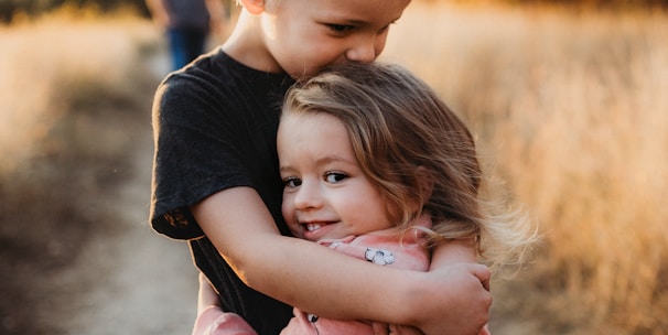 boy in black t-shirt hugging girl in red and white polka dot dress