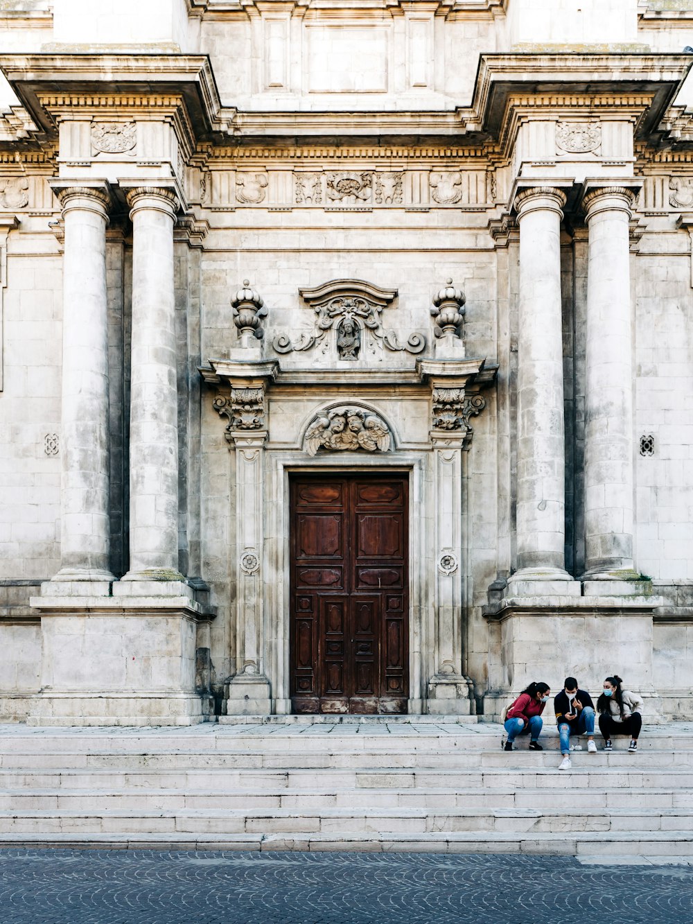 people sitting on concrete building during daytime