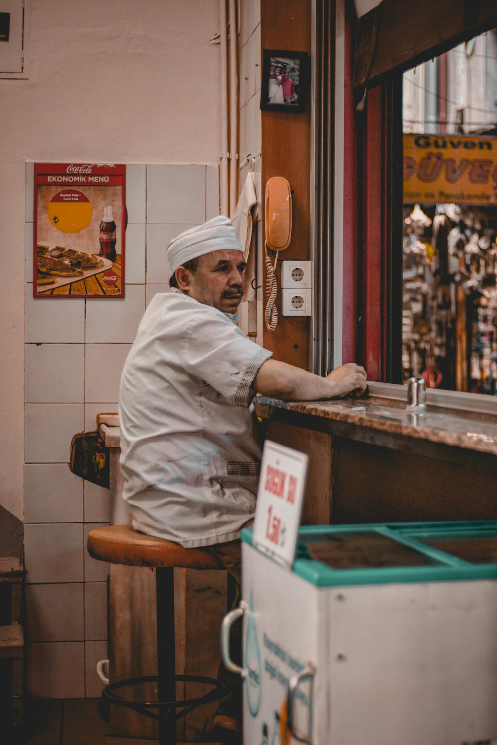 man in white chef uniform sitting on brown wooden chair