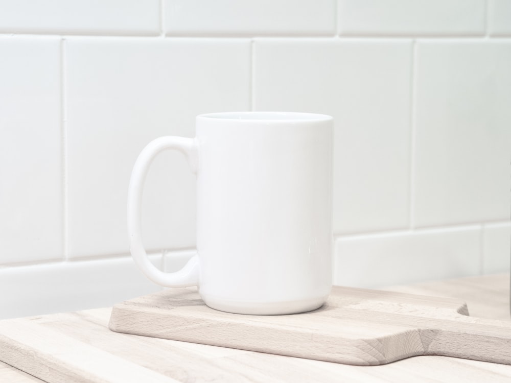 white ceramic mug on brown wooden chopping board