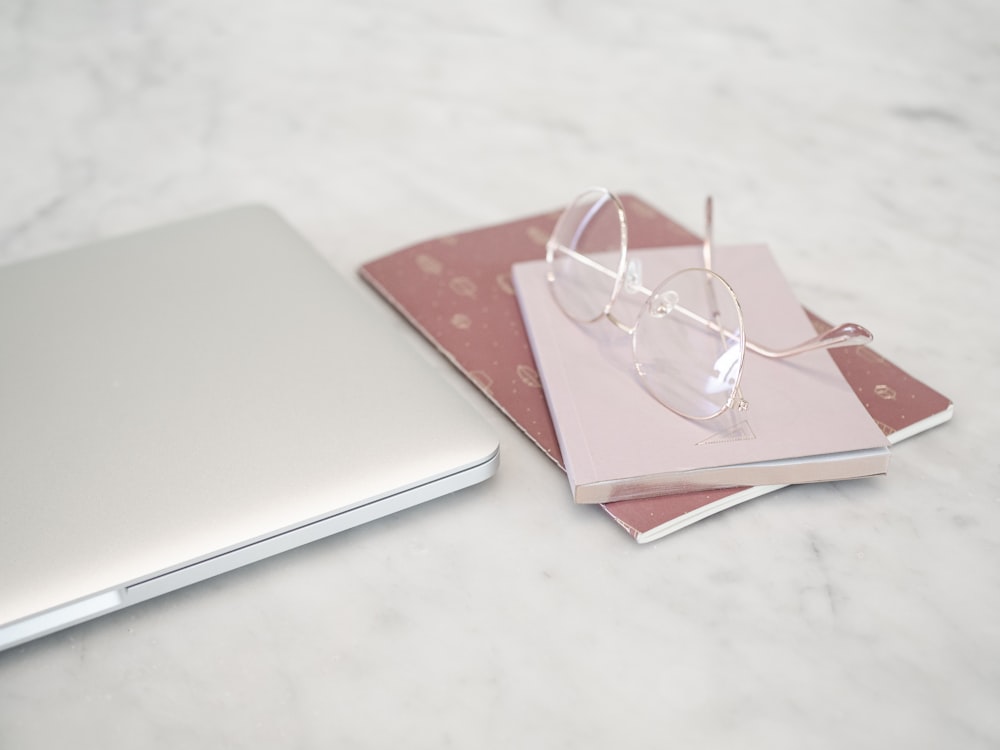 silver macbook on white table