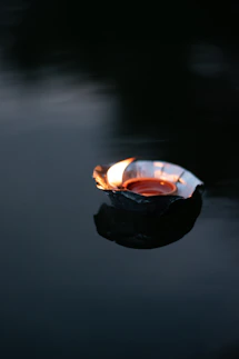 lighted candle in black round container