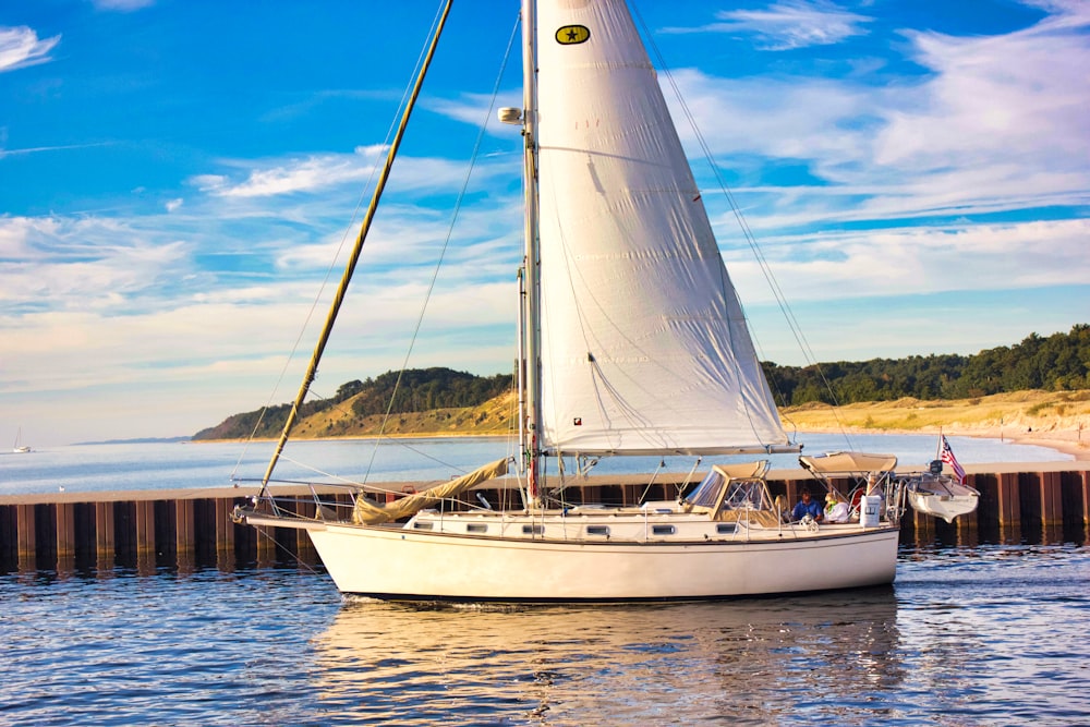 white sail boat on sea during daytime