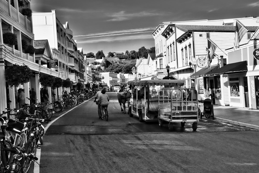 grayscale photo of people walking on street near buildings