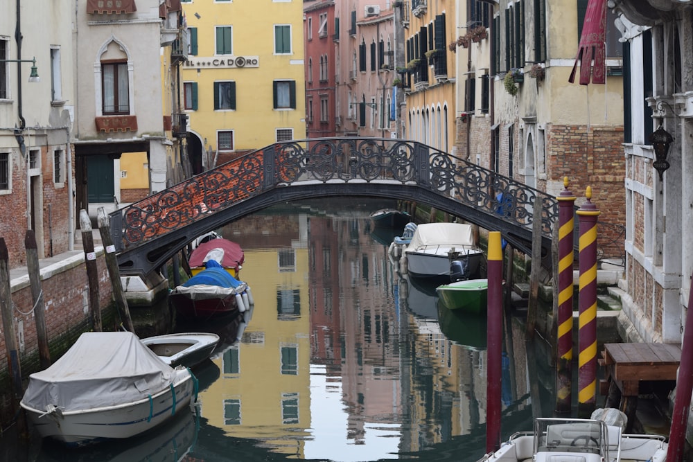 a bridge over a canal with boats in it