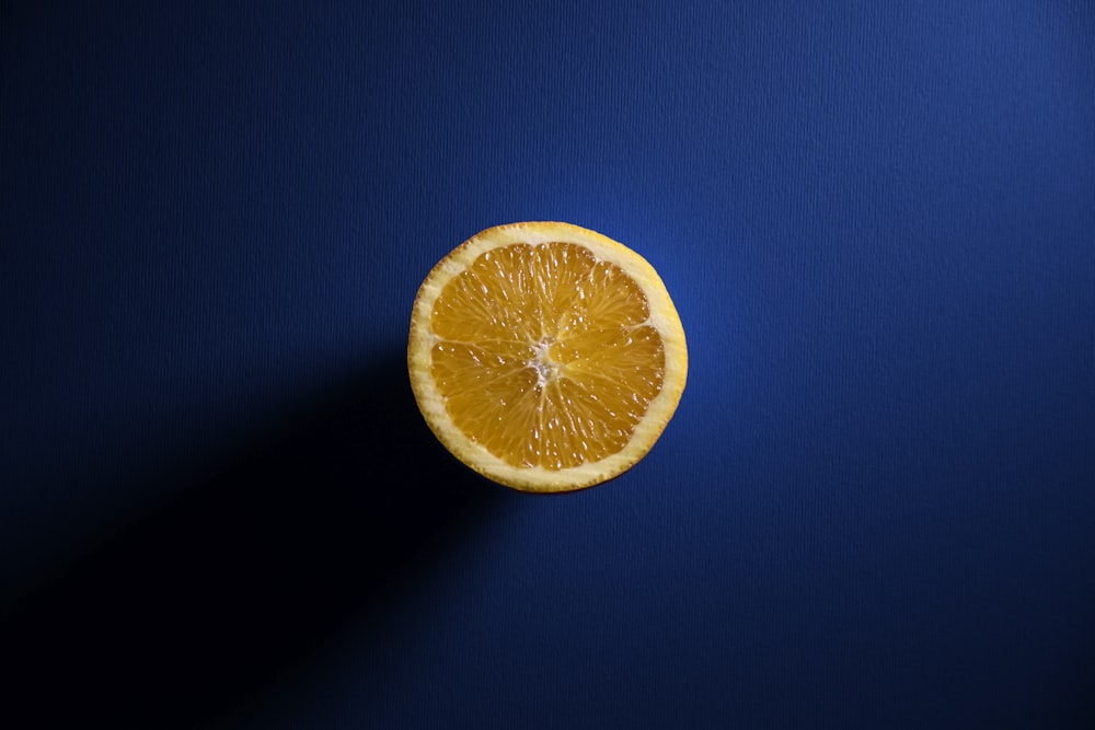 sliced orange fruit on blue surface