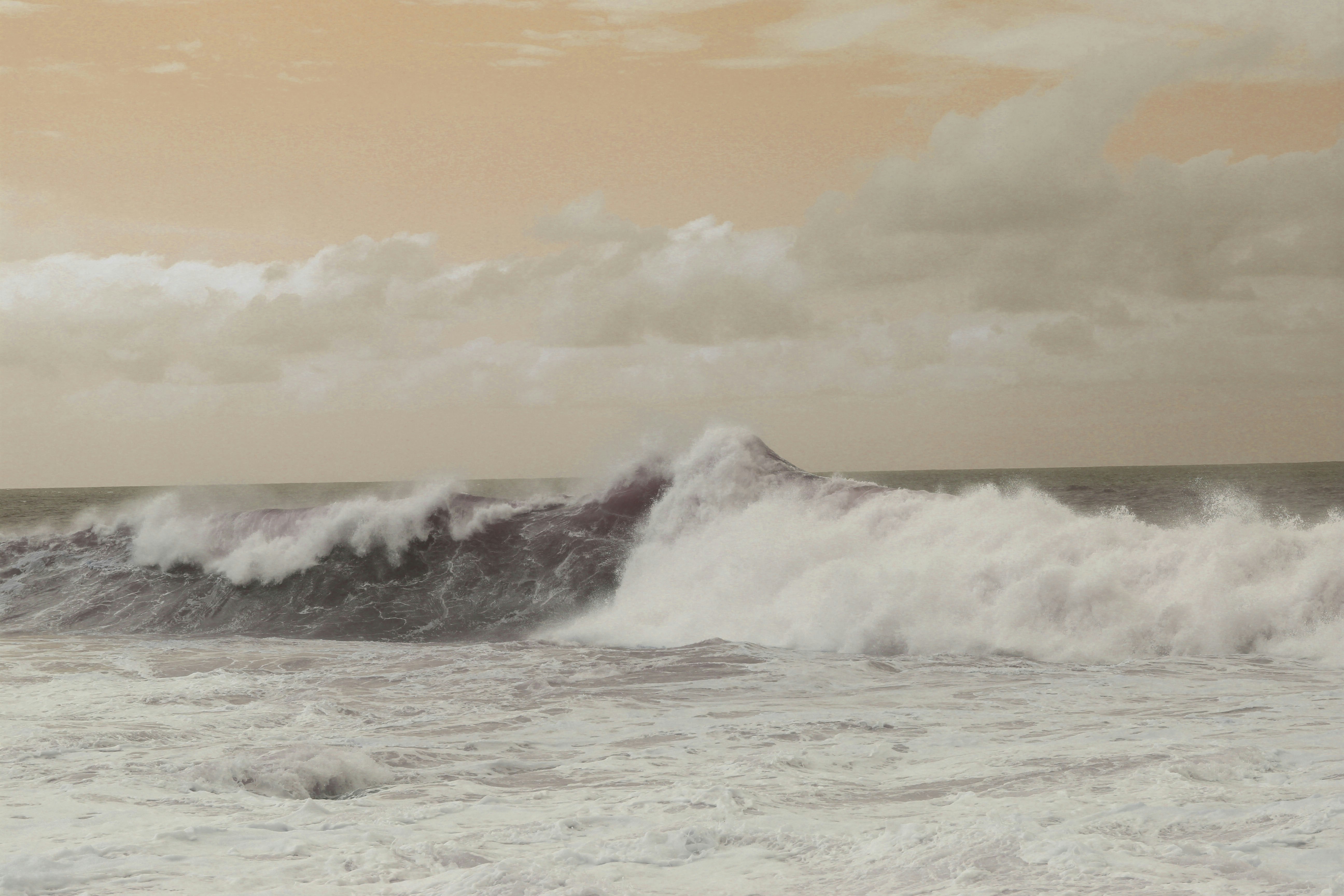 ocean waves under cloudy sky during daytime