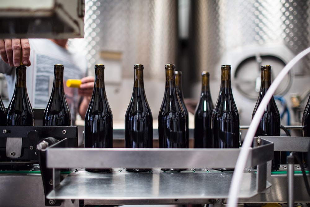 black glass bottles on stainless steel table