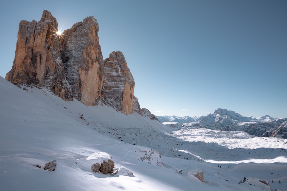 brown rocky mountain covered by snow under blue sky during daytime