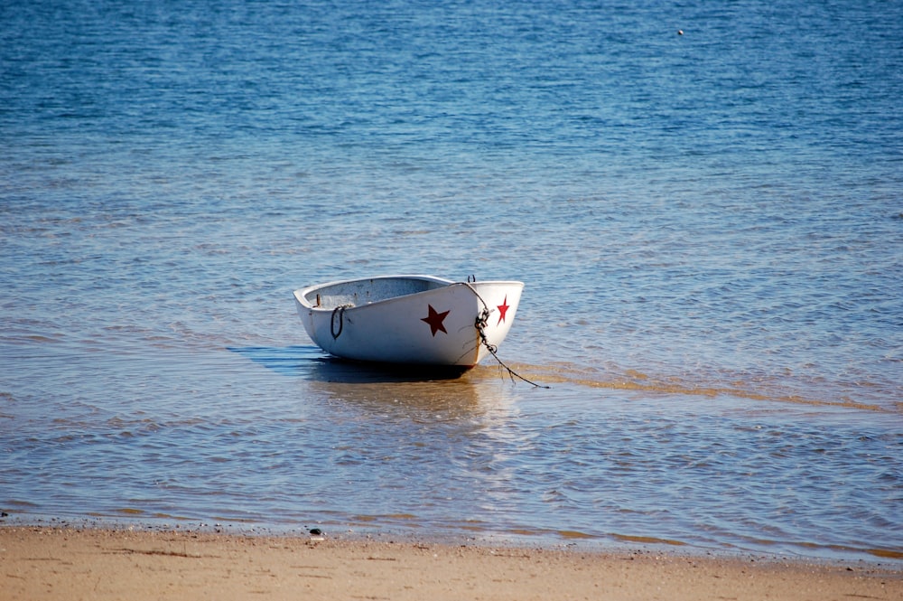 white boat on sea shore during daytime