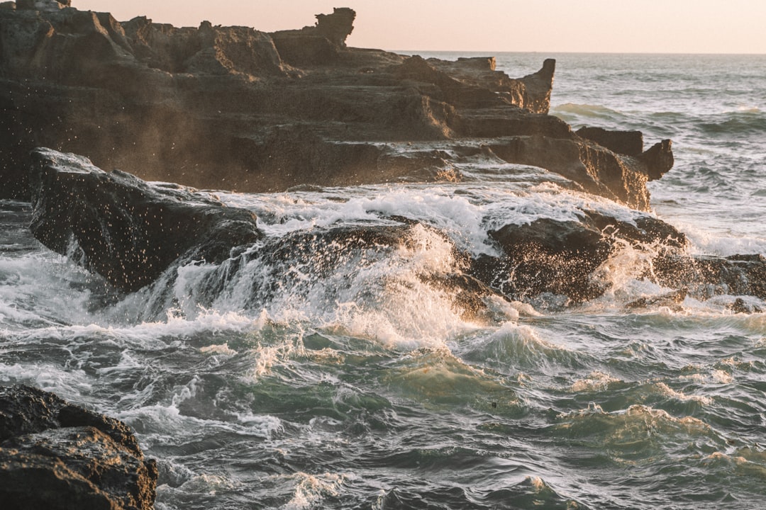 ocean waves crashing on rocky shore during daytime