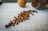 Close-up of a Caféaura coffee jar with coffee beans scattered around on a rustic wooden table.