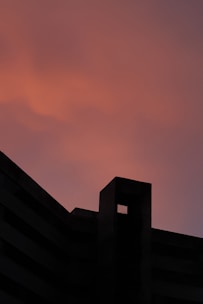 A thermal energy storage facility with layered solid-mass architecture glowing under sunset.