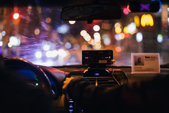 A professional taxi driver installing a sleek Carbynevo dashcam inside their vehicle.