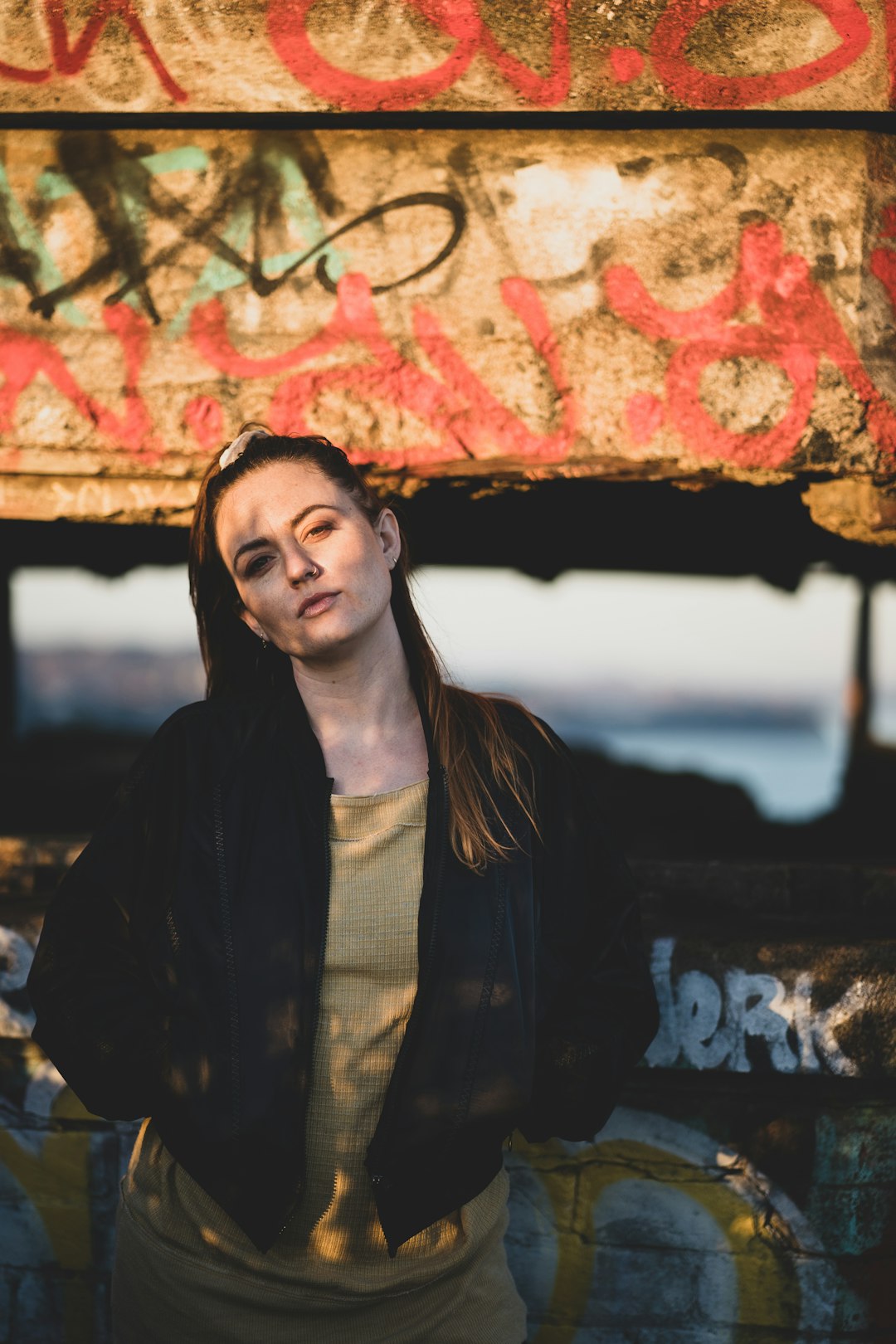 woman in black coat standing near wall