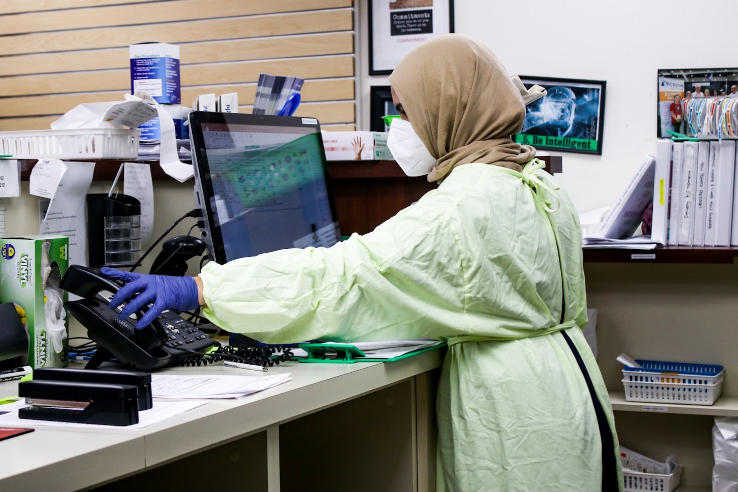 Hijab wearing nurse behind counter