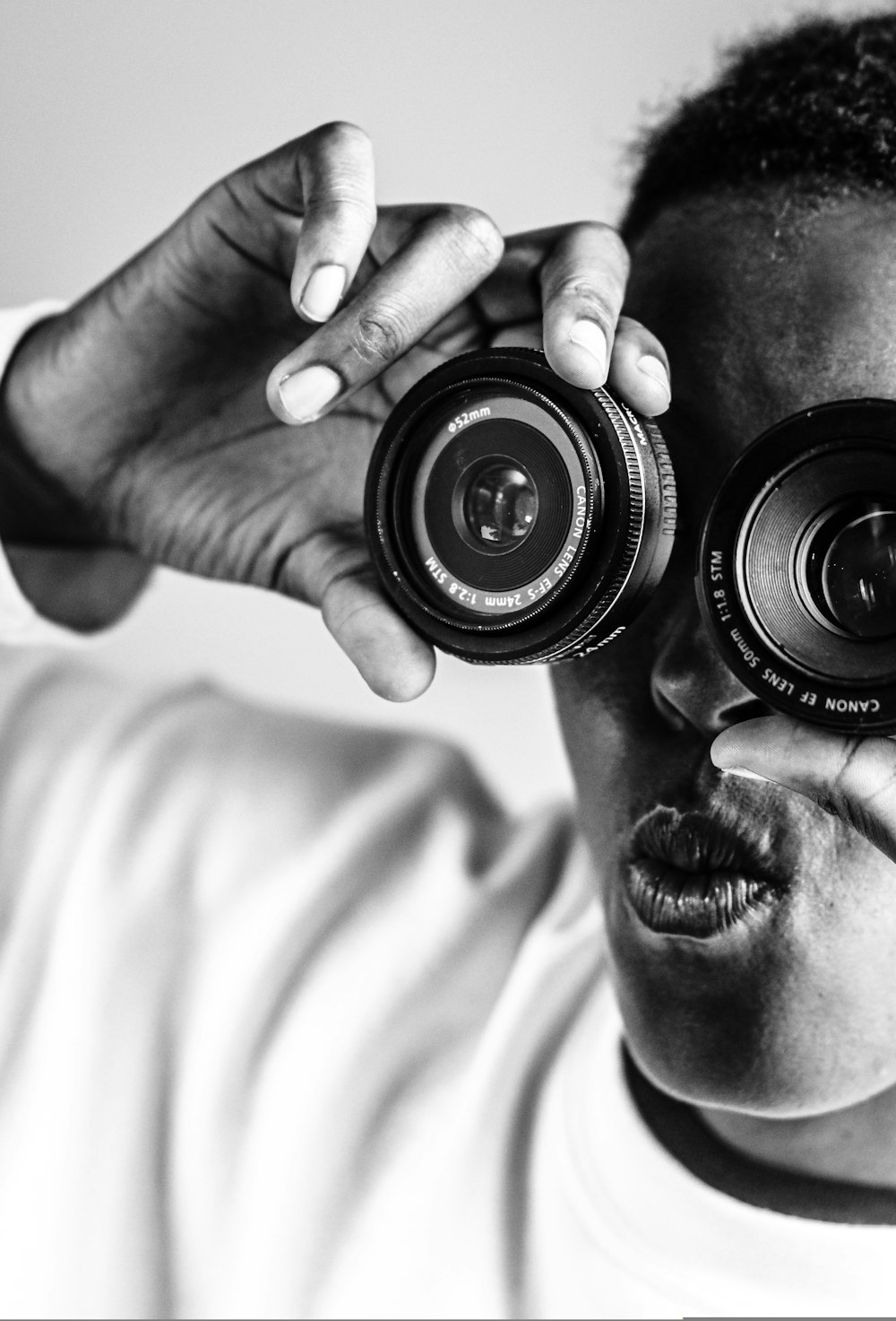 grayscale photo of man holding camera lens