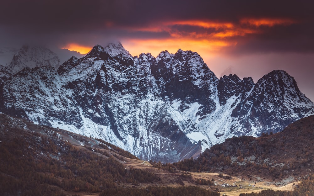 snow covered mountain during sunset