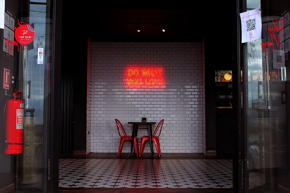 a table and chairs in a room with a brick wall