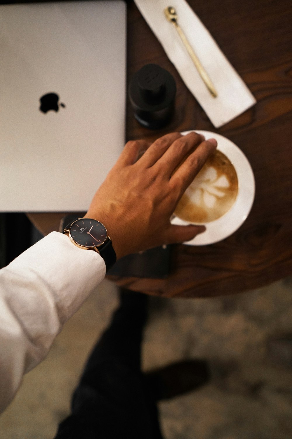 a person holding a plate of food in front of a laptop