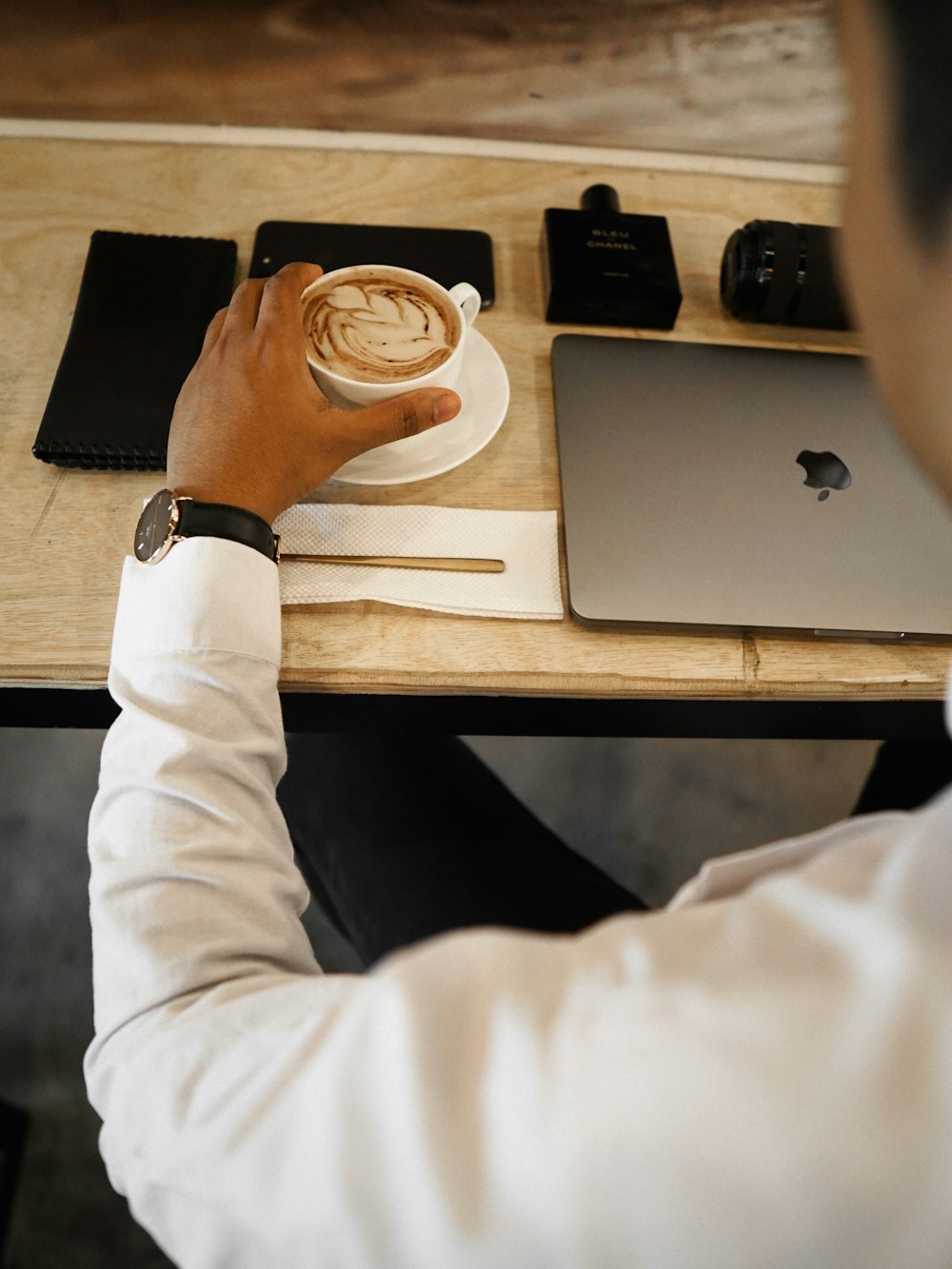 a man sitting at a table with a cup of coffee