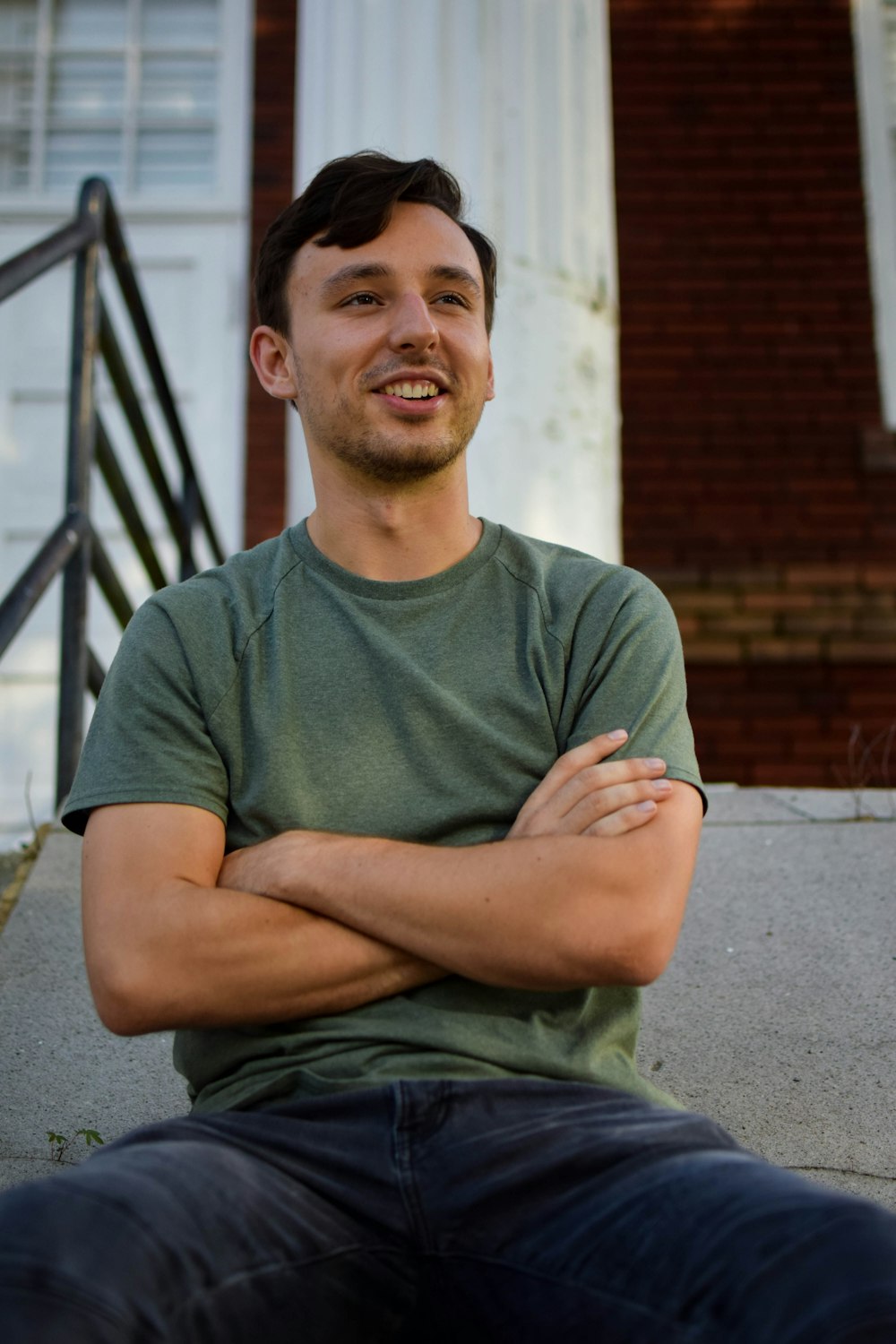 a man sitting on a step with his arms crossed