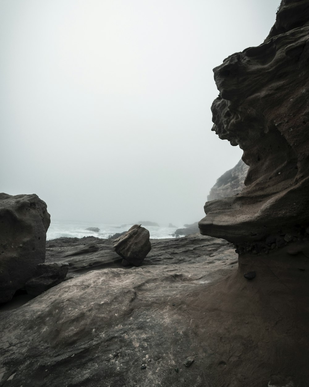 brown rock formation near body of water during daytime