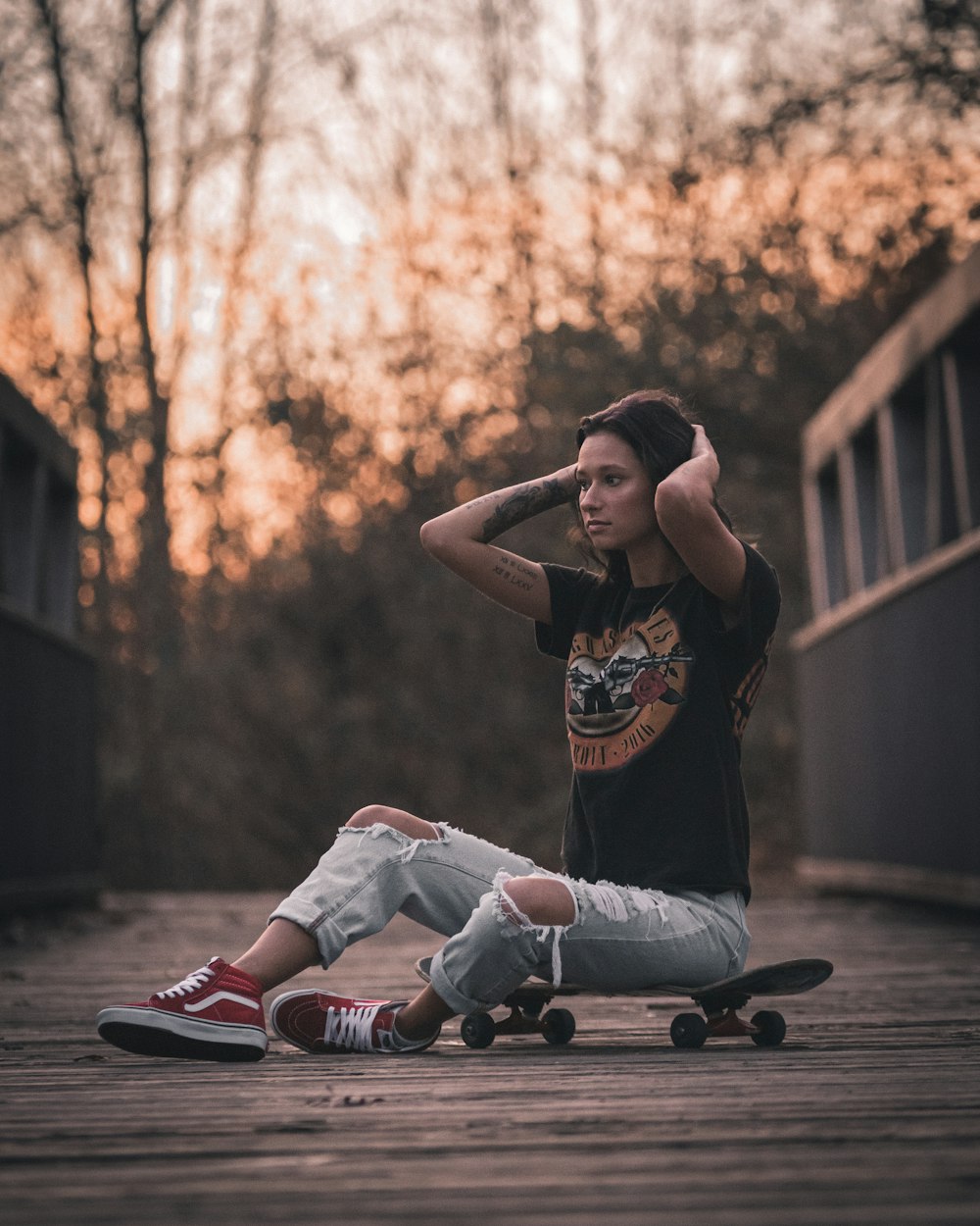 woman in black and white tank top and white pants sitting on brown wooden bench during